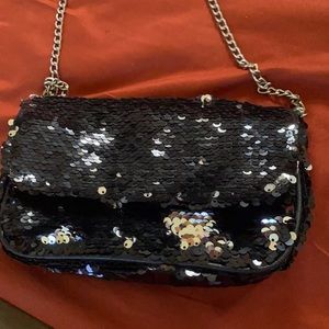 This bag is so cute. It’s black but when you slide your hand up it turns silver.